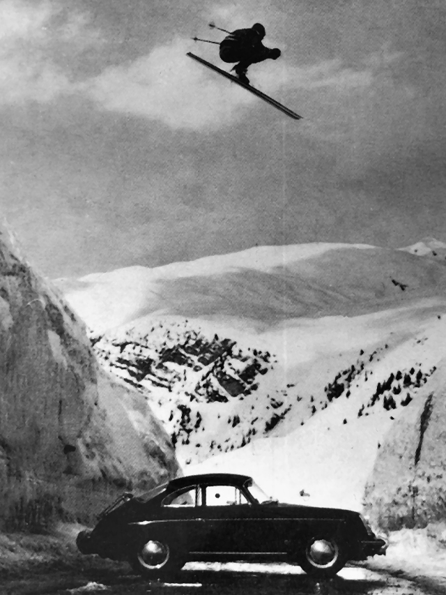 Vintage ski jumper soars over the vehicle and the road