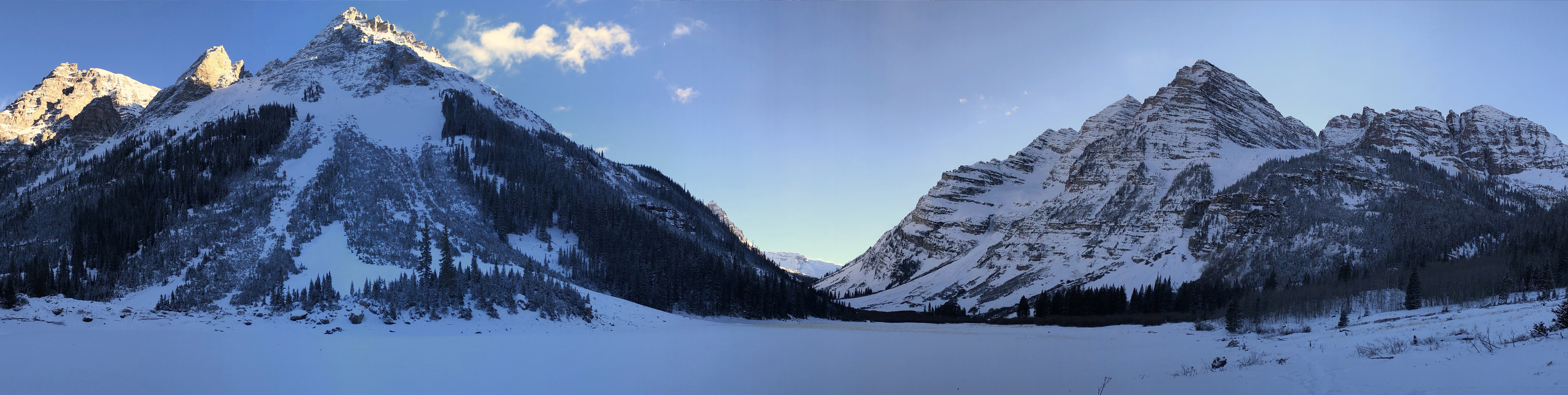 Early spring snows cover Crater Lake at the base of Maroon Bells in Aspen, Colorado